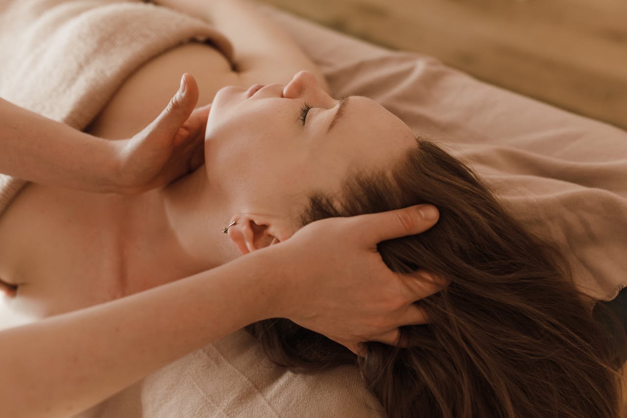 A Person Massaging a Woman's Face